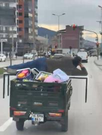 Motosikletin arkasında yatarak tehlikeli yolculuk